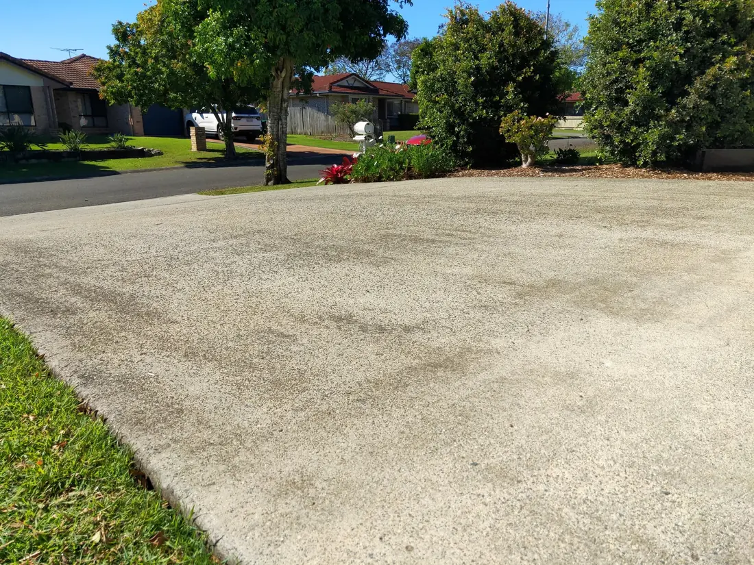 Faded, patchy exposed aggregate driveway before coating