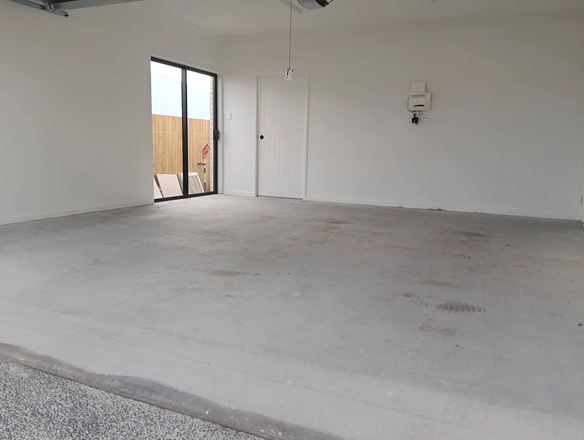 Bare grey concrete slab in a new double garage before coating