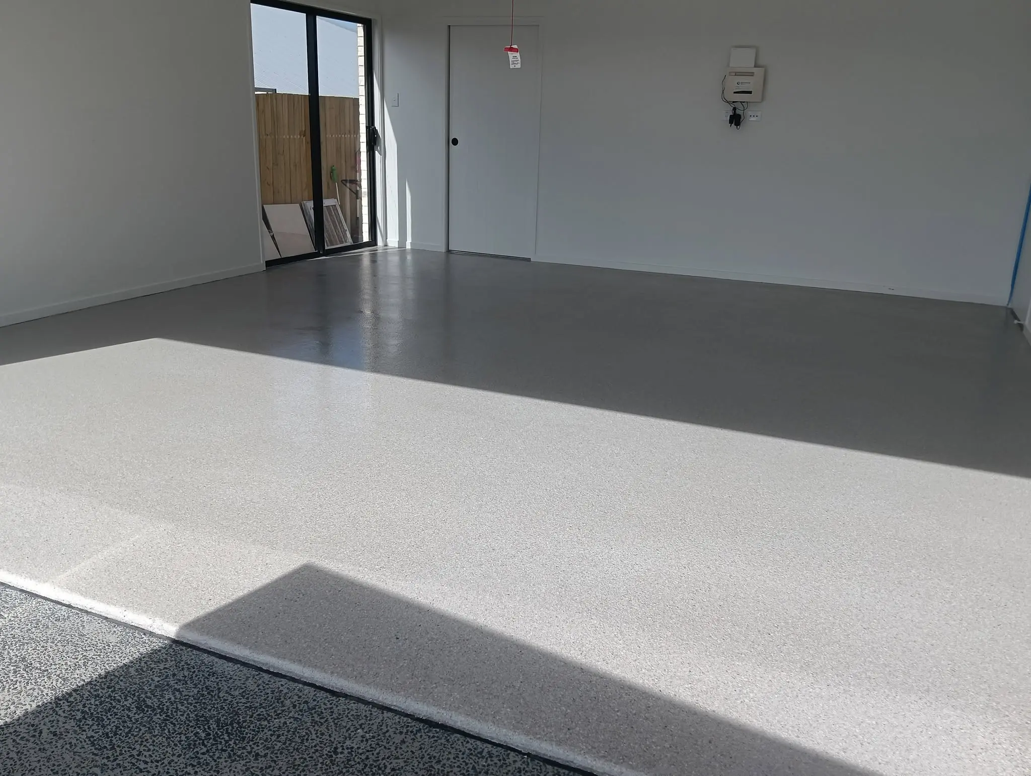 The same double garage finished in a light grey epoxy flake coating